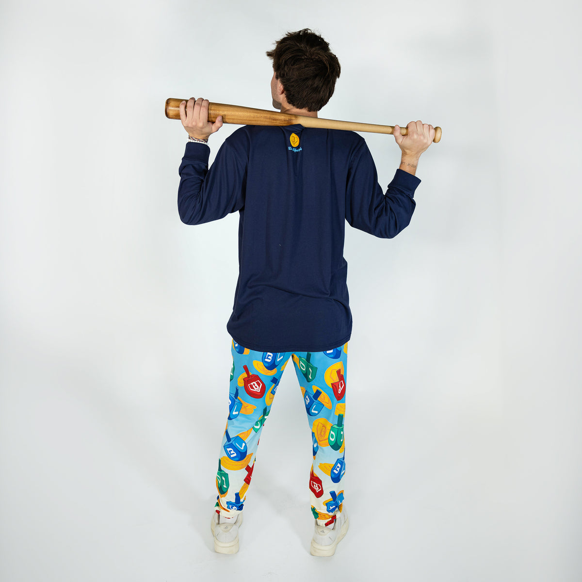 Adult model wearing blue pajama pants with "Spin & Swing" design