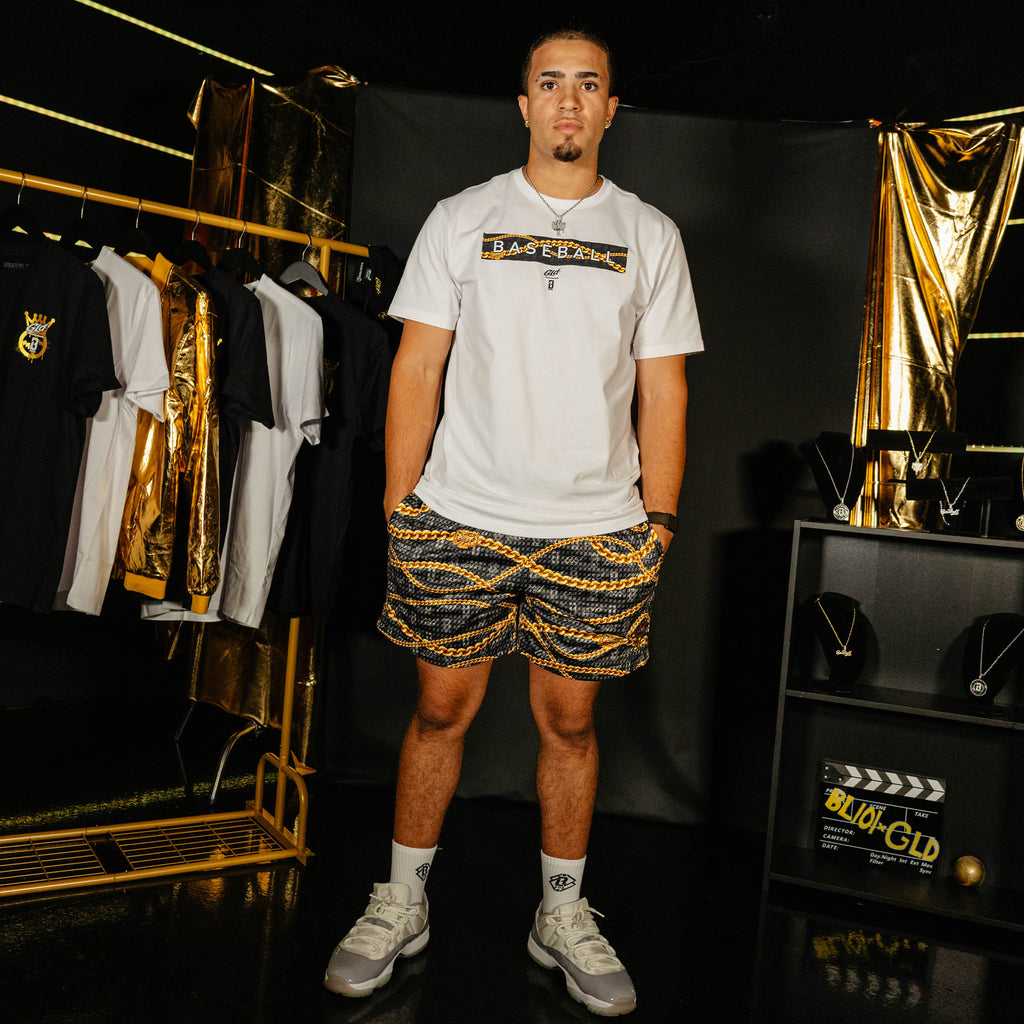Adult model wearing black shorts with "BL101 X GLD" design