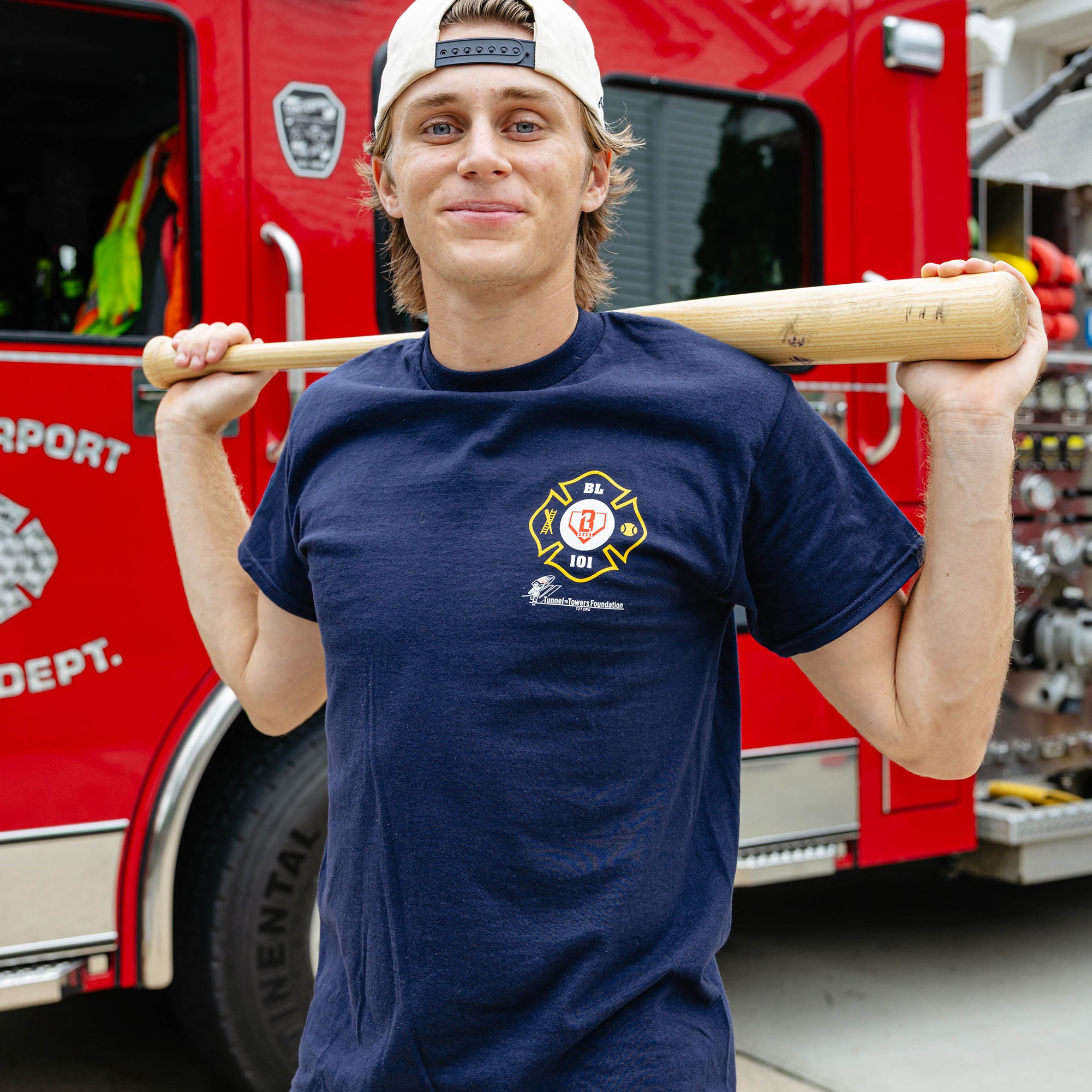 Adult model wearing Navy graphic tee with "BL101 X Tunnel to Towers Foundation" design