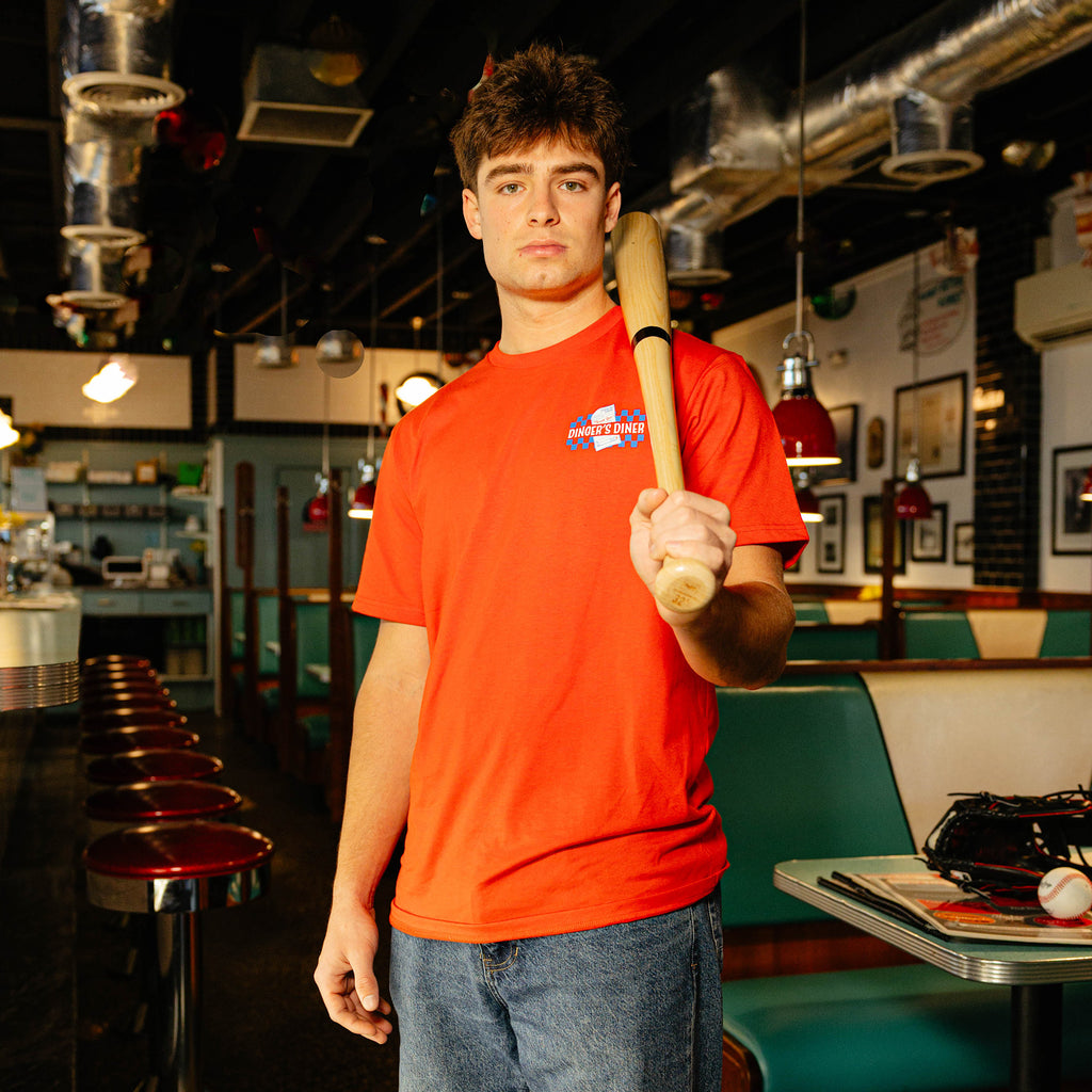 Person wearing a red t-shirt with a 'Dinger's Diner' logo on the front.