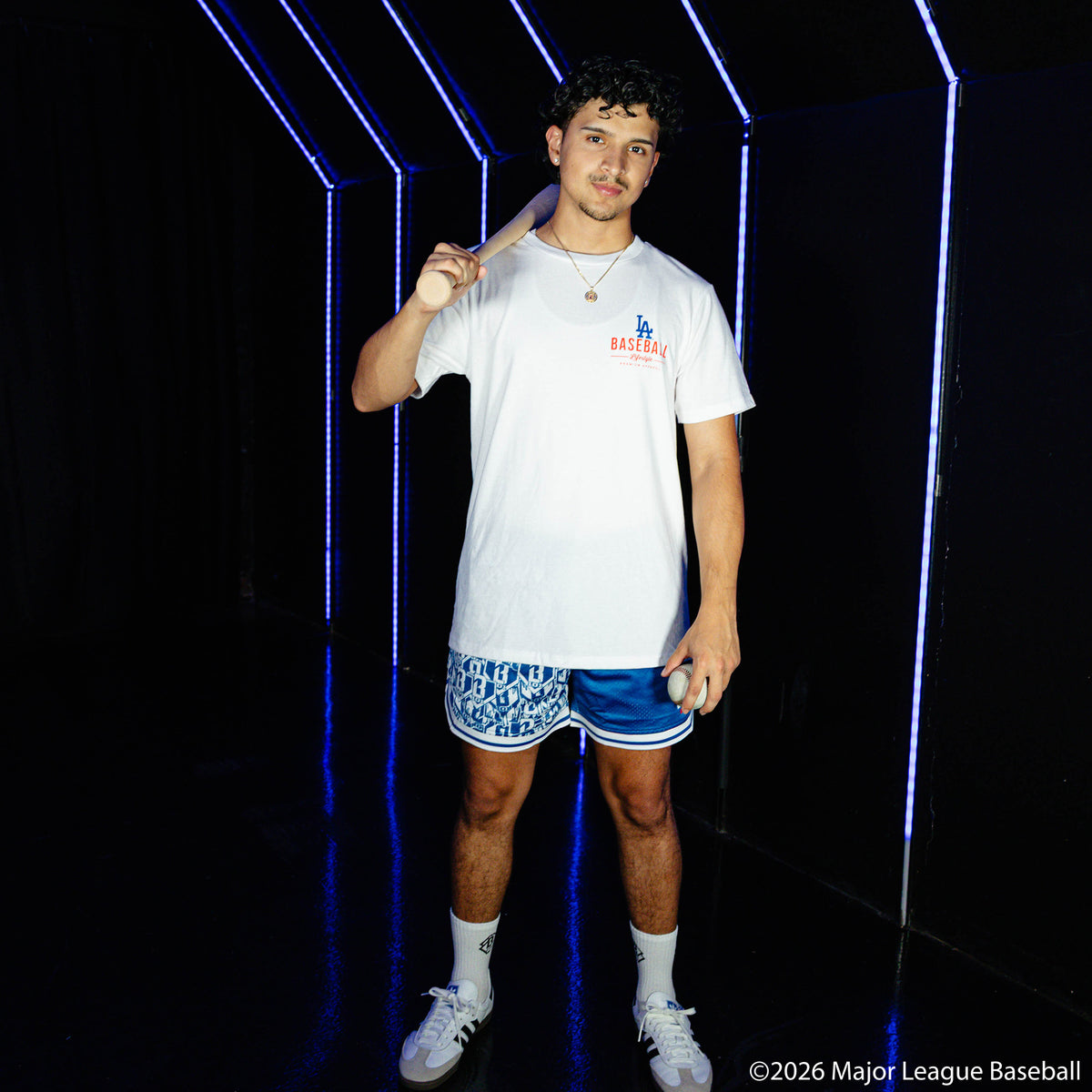 Adult model wearing blue shorts with "Los Angeles Dodgers Sticker Court" design
