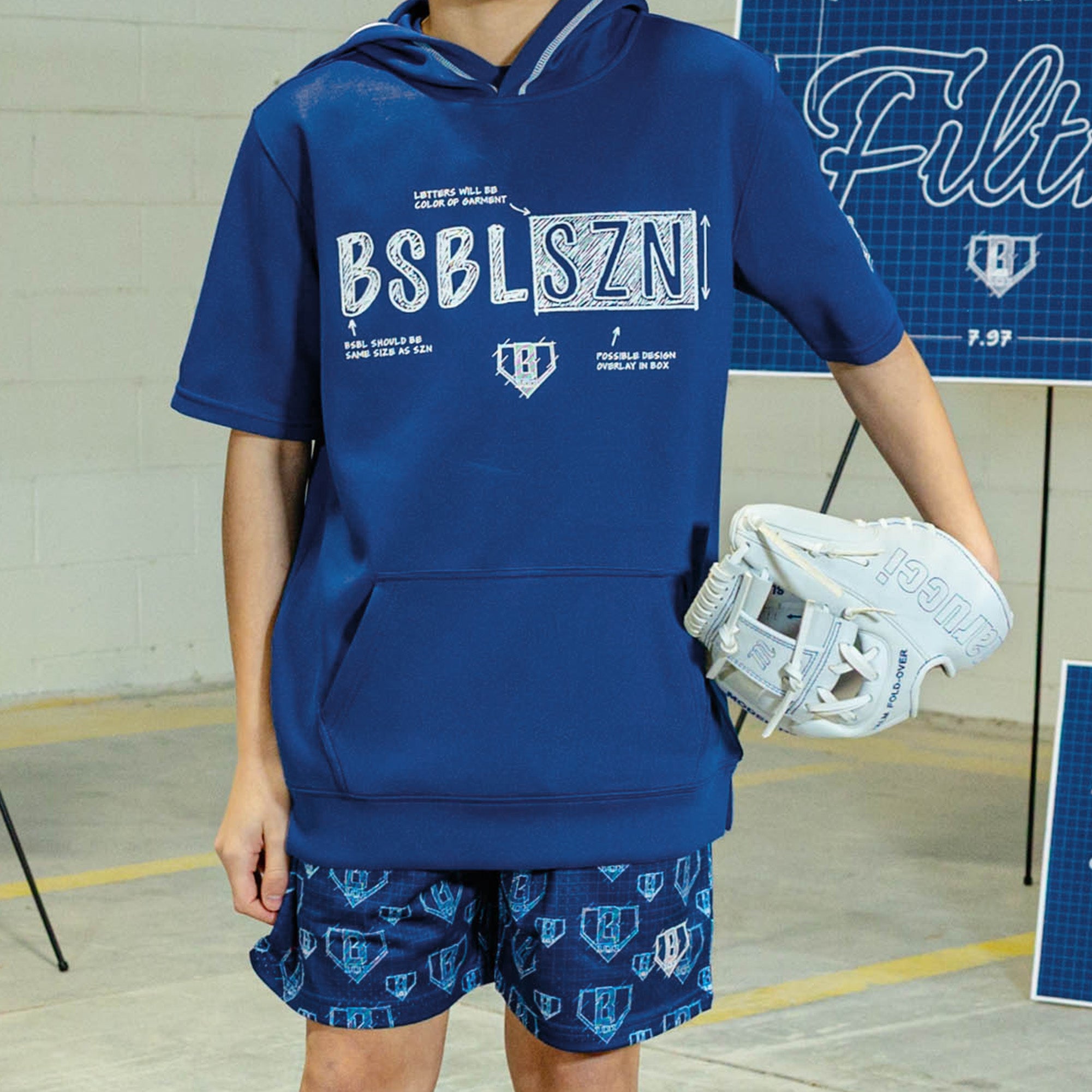 Person wearing a blue hoodie and Blue shorts with white BL101 graphic pattern 
