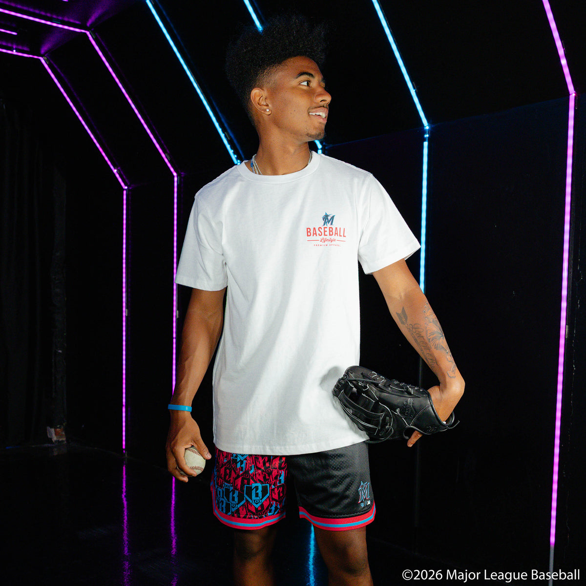 Adult model wearing black shorts with "Miami Marlins Sticker Court" design