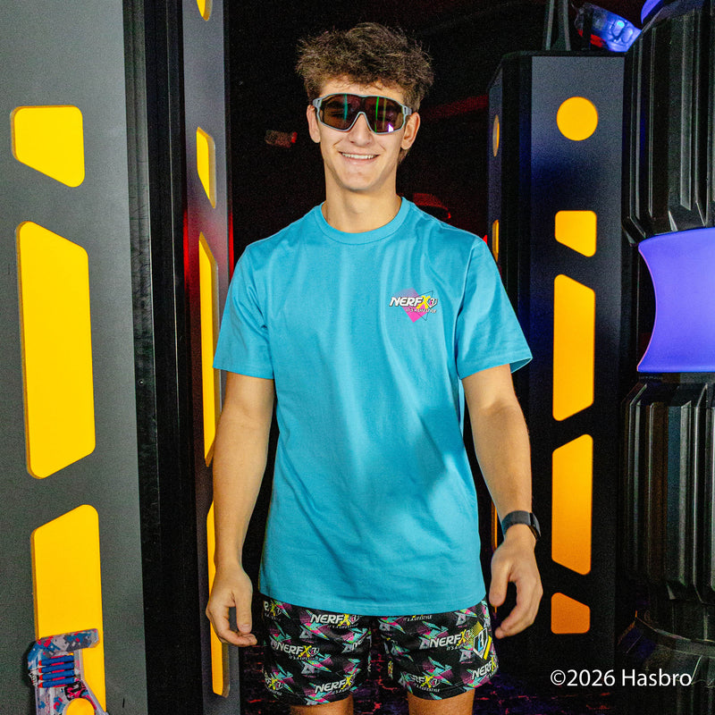 Person wearing a blue shirt and black shorts with colorful 'Nerf x BL101' logo pattern, standing in front of a black and yellow background