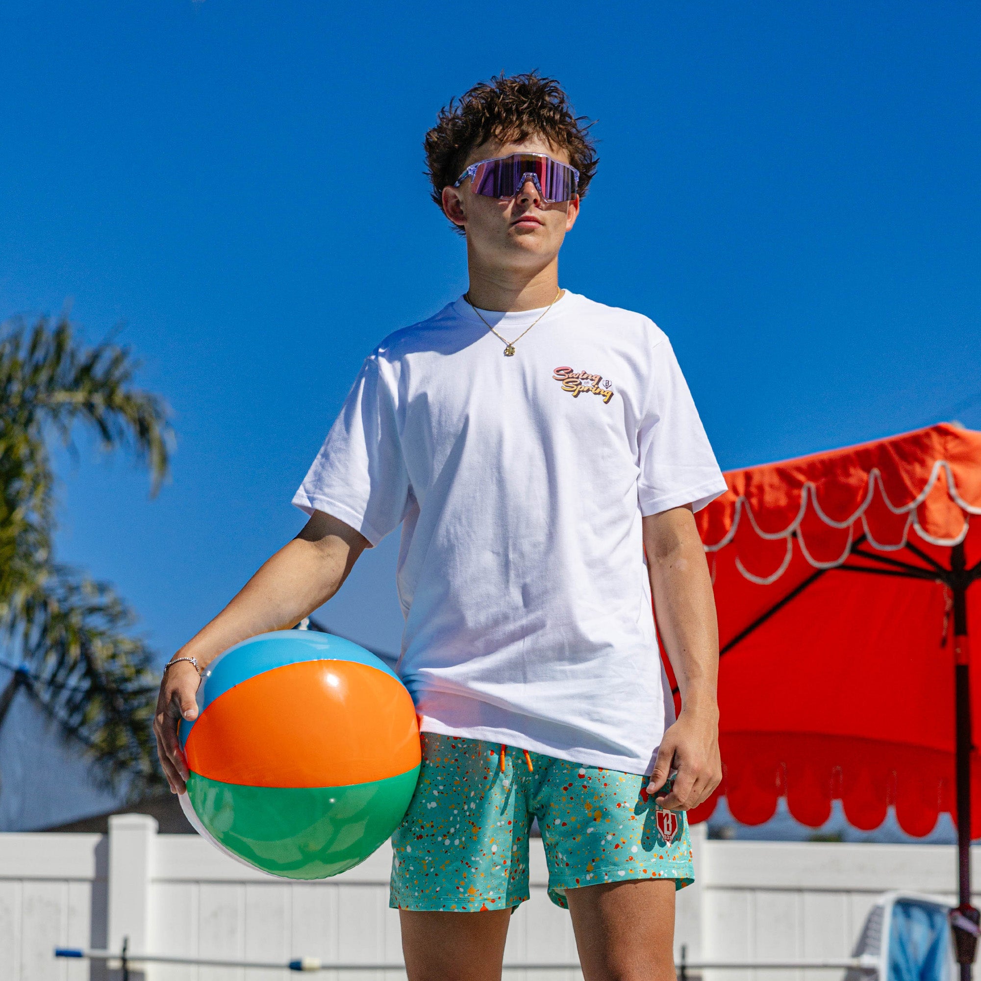 Youth model wearing blue Splatter Swim Trunks Teal youth trunks