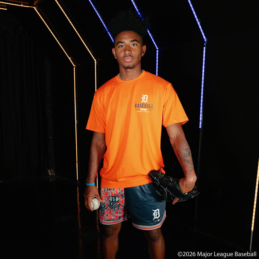 Adult model wearing navy shorts with "Detroit Tigers Sticker Court" design