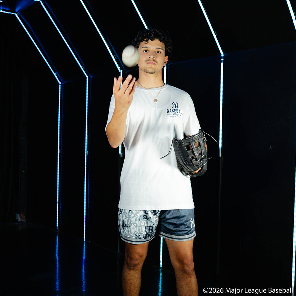 Adult model wearing navy shorts with "New York Yankees Sticker Court" design