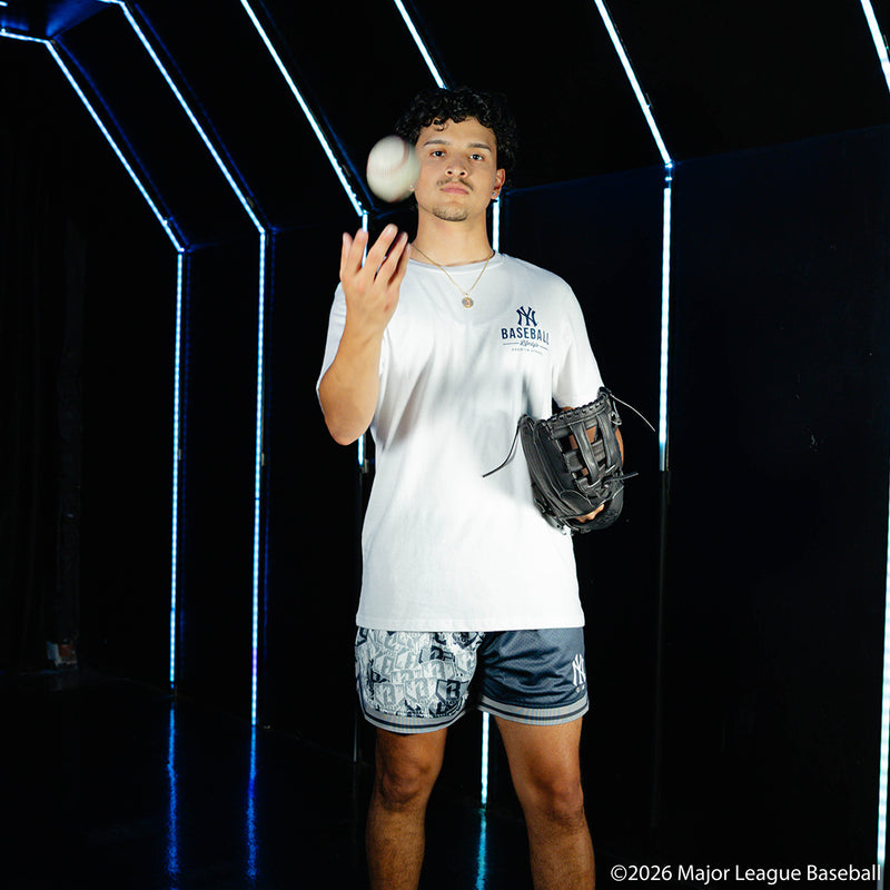 Adult model wearing navy shorts with "New York Yankees Sticker Court" design
