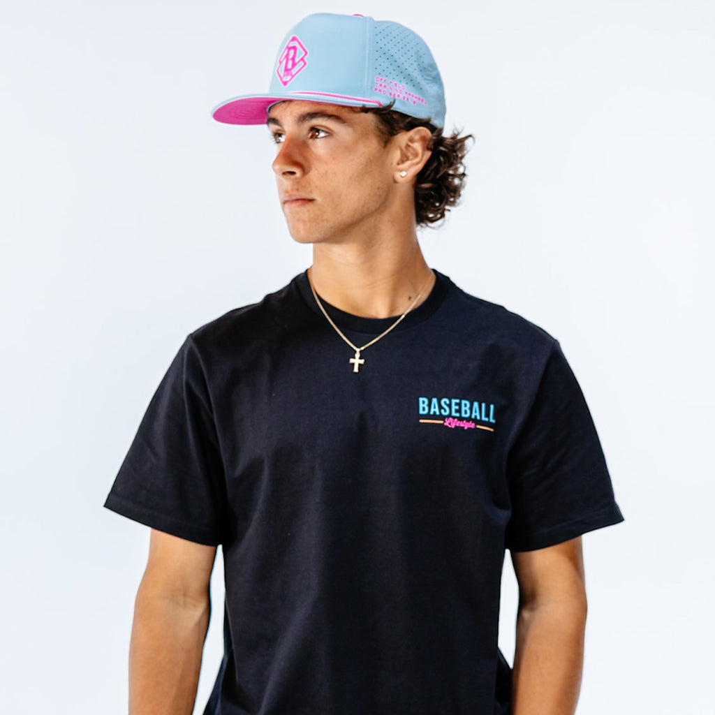 Person wearing a black t-shirt with 'BASEBALL Lifestyle' text and a light blue cap on a white background