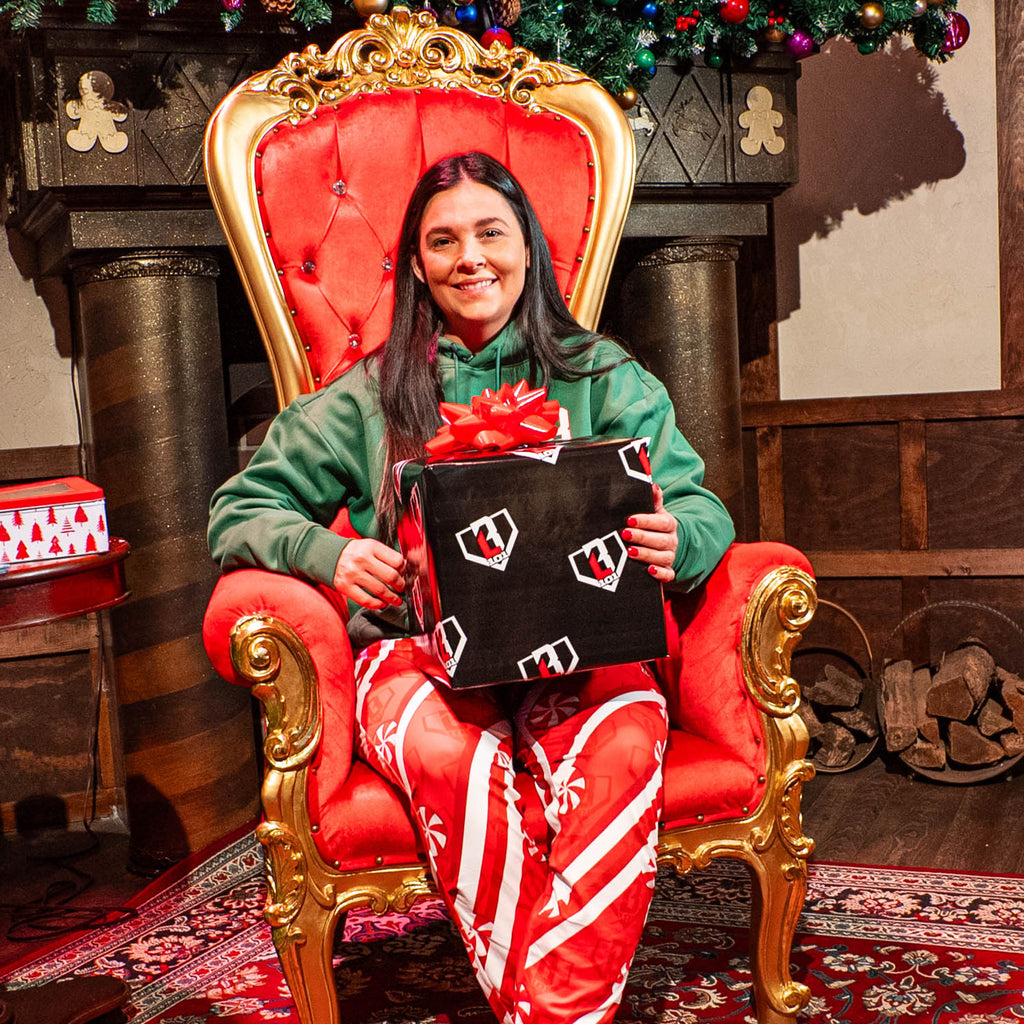 Person wearing Red pants with candy cane design and BL101 logo sitting in chair