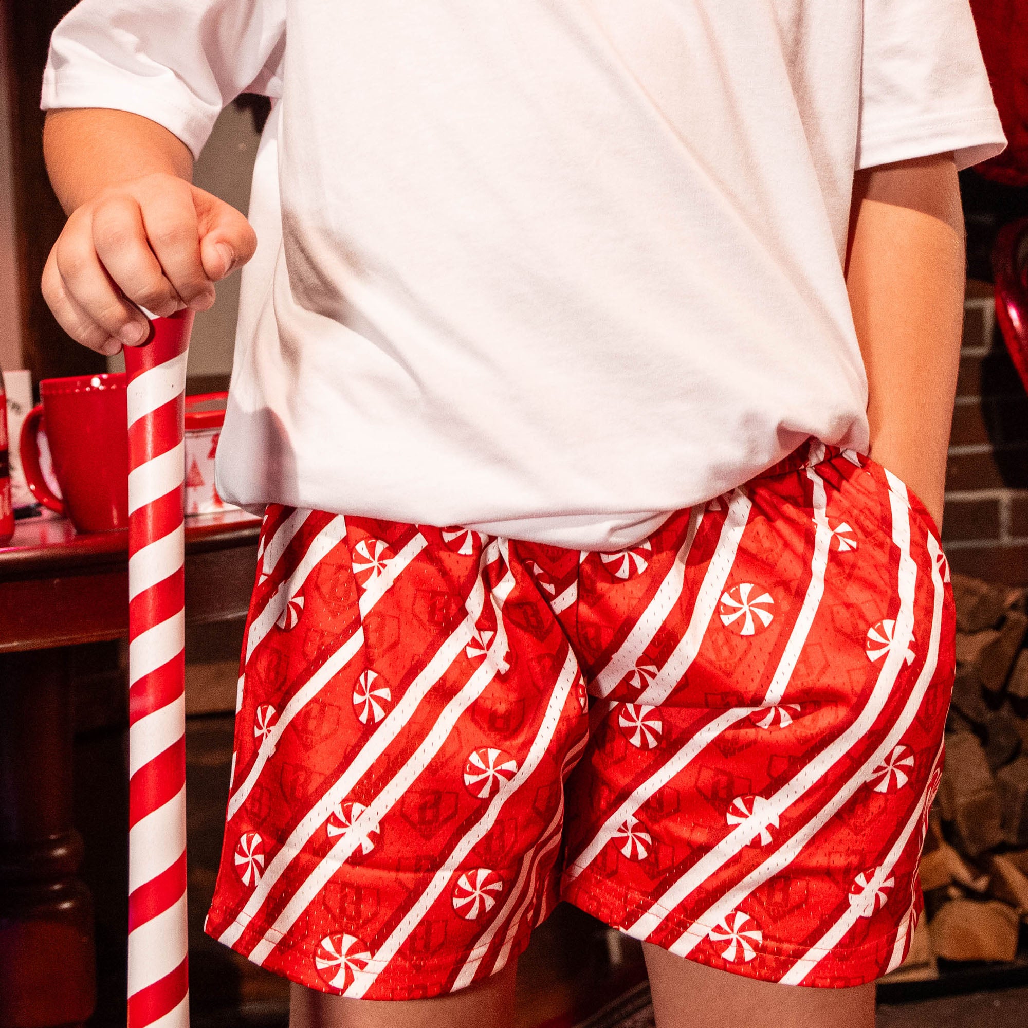 close up of person wearing red shorts with candy cane pattern and red BL101 logo
