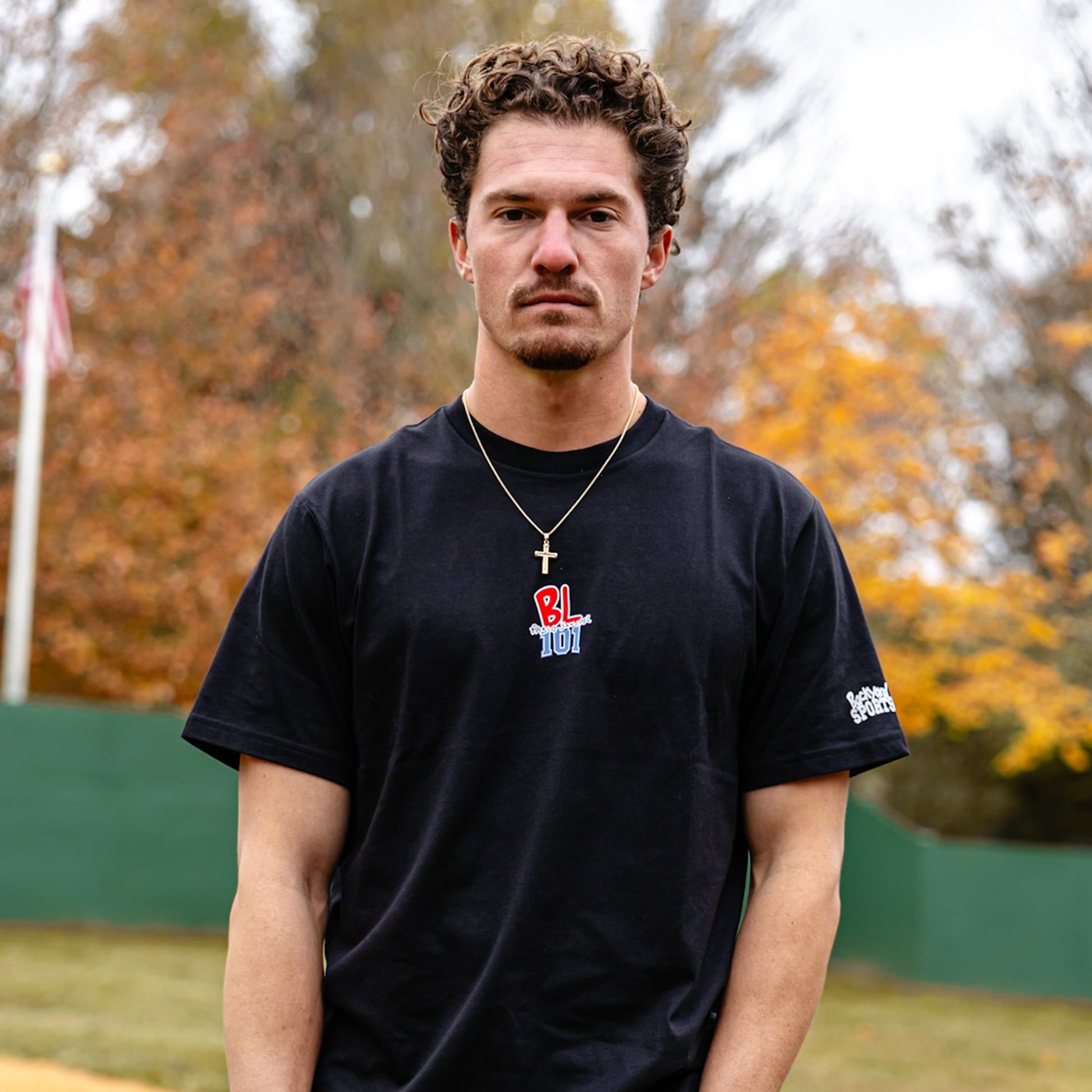 Man wearing a black t-shirt with 'BL101 Pablo Sanchez' logo outdoors