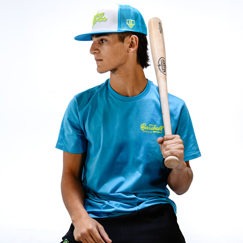 Person wearing a blue shirt and cap holding a baseball bat on a white background