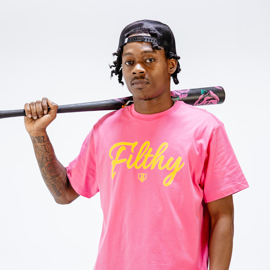 Person wearing a pink 'Filthy' t-shirt holding a baseball bat against a white background