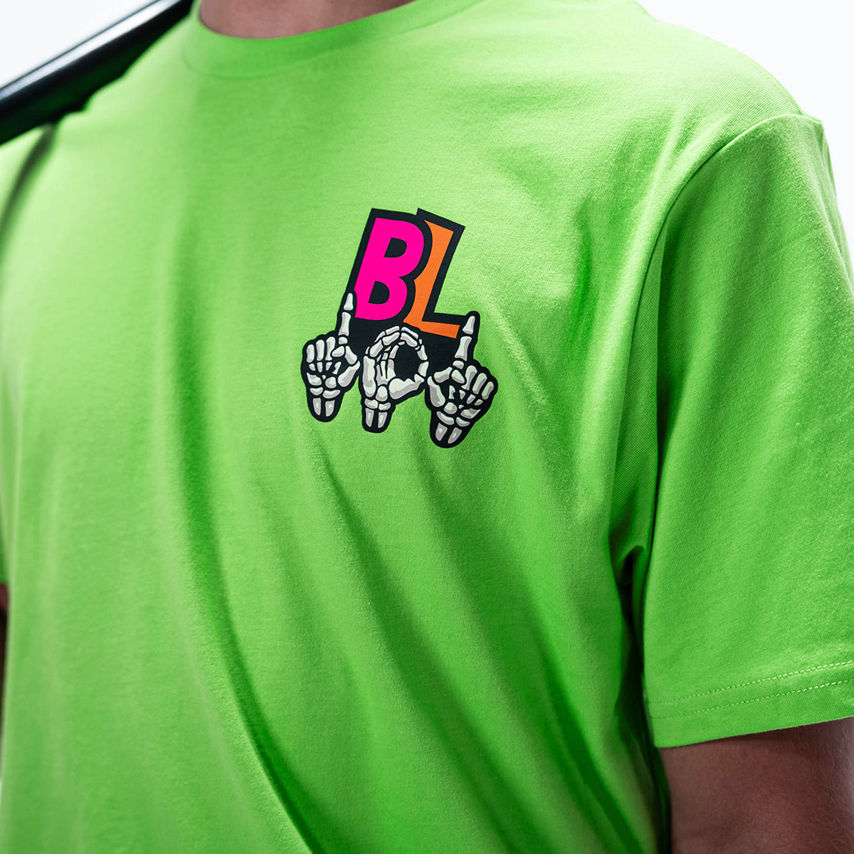 Adult model wearing green graphic tee with "101 Skeleton" design