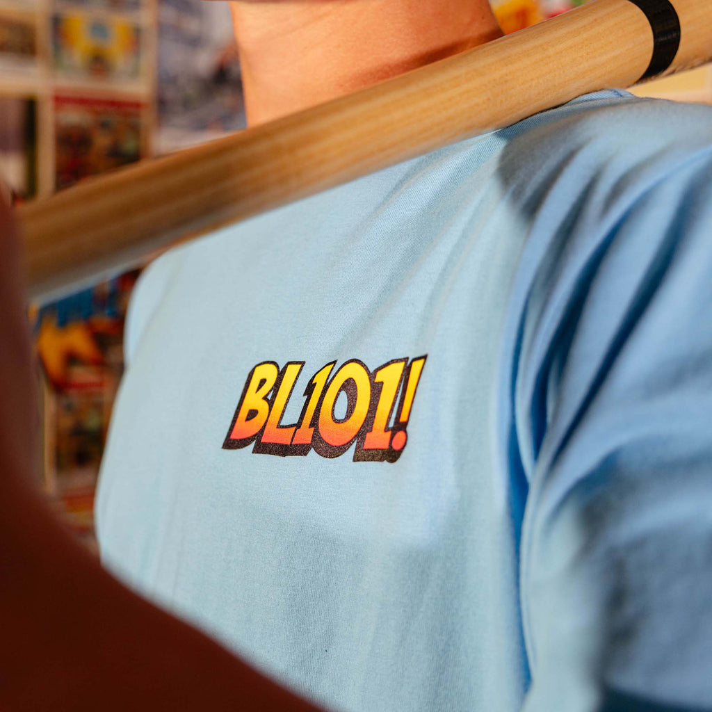 Adult model wearing blue graphic tee with "BL101 Comic" design