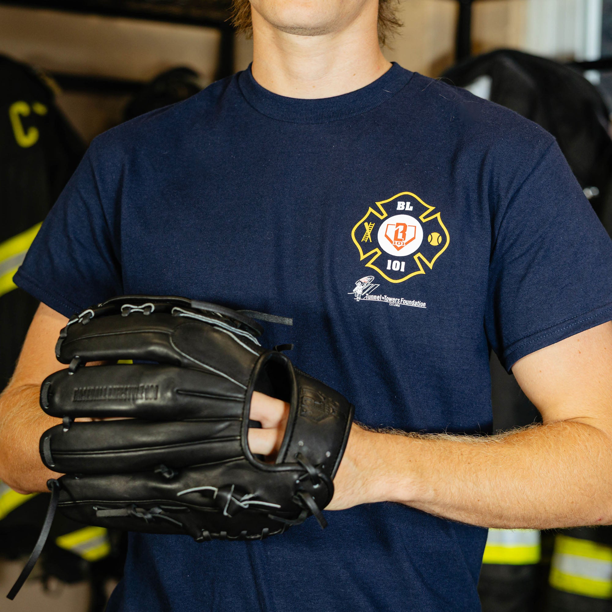 Adult model wearing Navy graphic tee with "BL101 X Tunnel to Towers Foundation" design