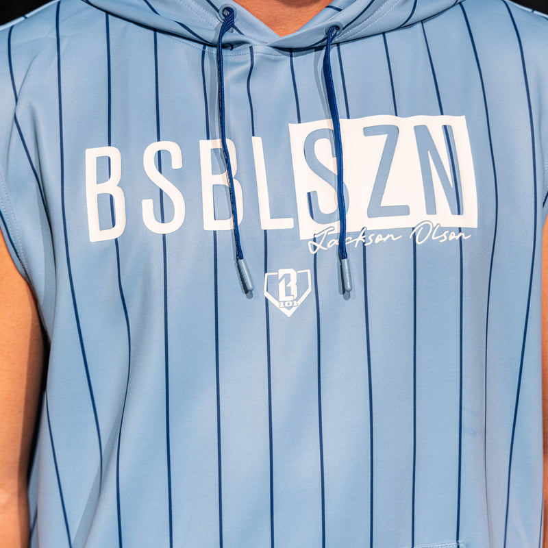 Close-up of the front graphic on the light blue pinstripe BSBL-SZN Short Sleeve Hoodie V3, showing the "BSBLSZN" box logo, "Jackson Olson" script, and BL101 home plate icon