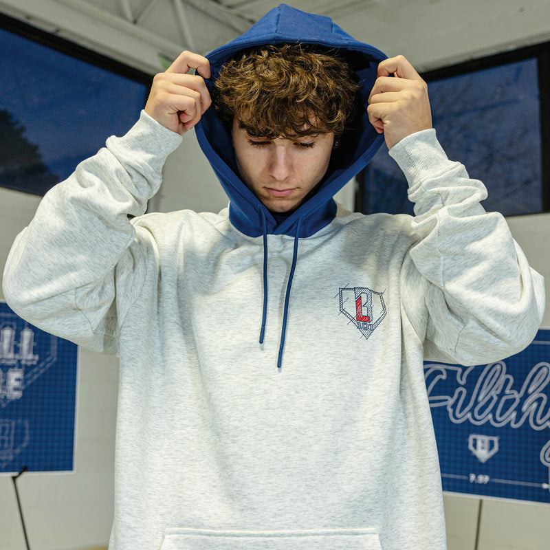 Person wearing a gray hoodie with blue hood with a blue an red BL101 logo