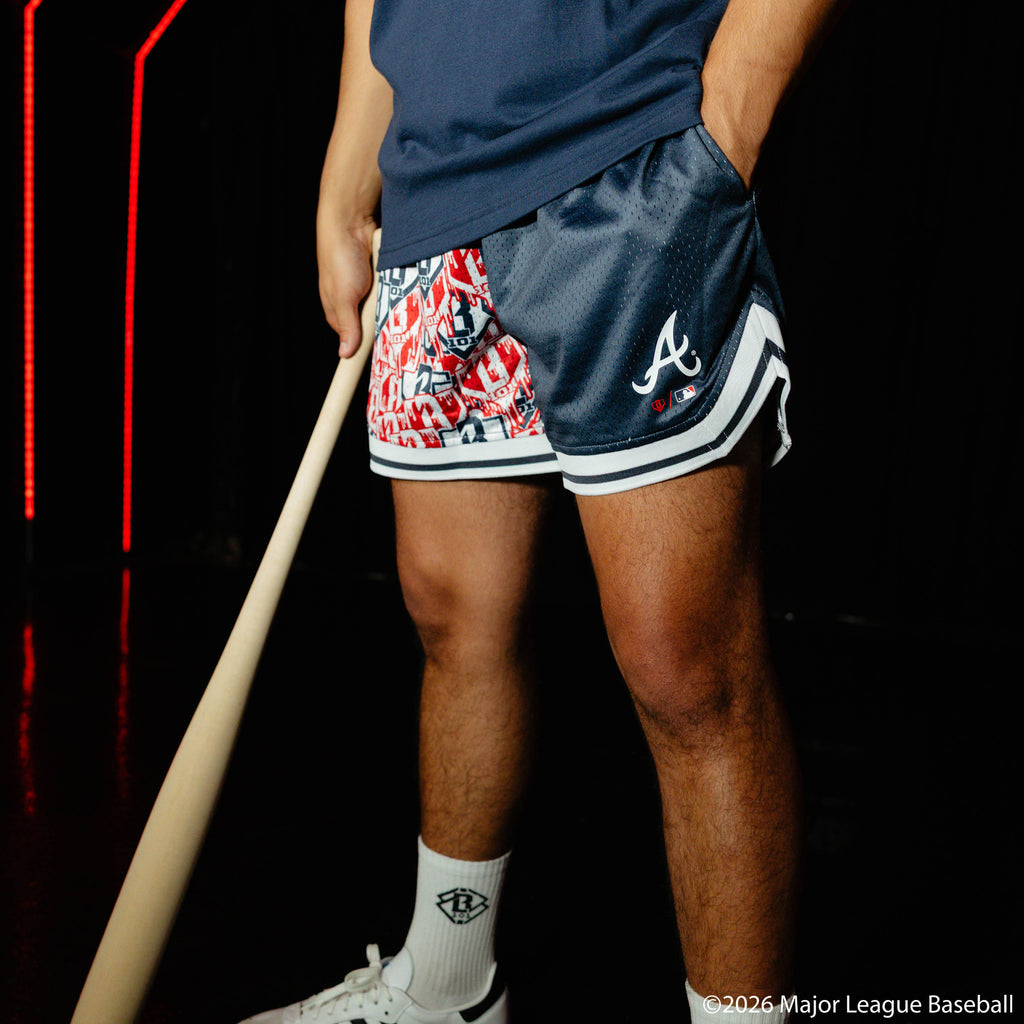 Adult model wearing navy shorts with "Atlanta Braves Sticker Court" design