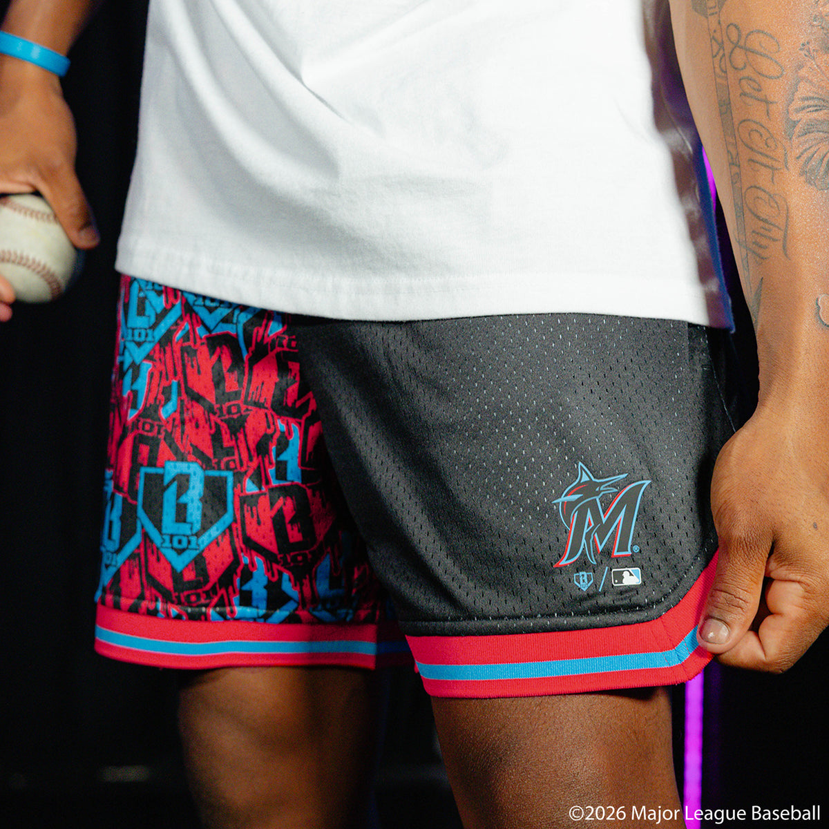 Adult model wearing black shorts with "Miami Marlins Sticker Court" design