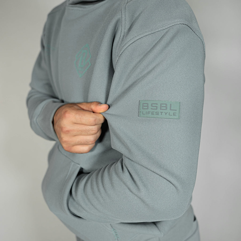 Adult model wearing gray Realtree Aspect Off-Field Waffle Performance Camo hoodie