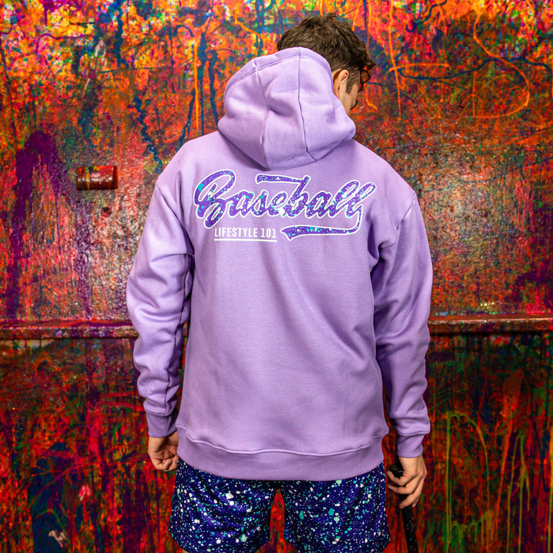 Person wearing a purple hoodie with 'Baseball Lifestyle' text, standing in front of a colorful, abstract wall.