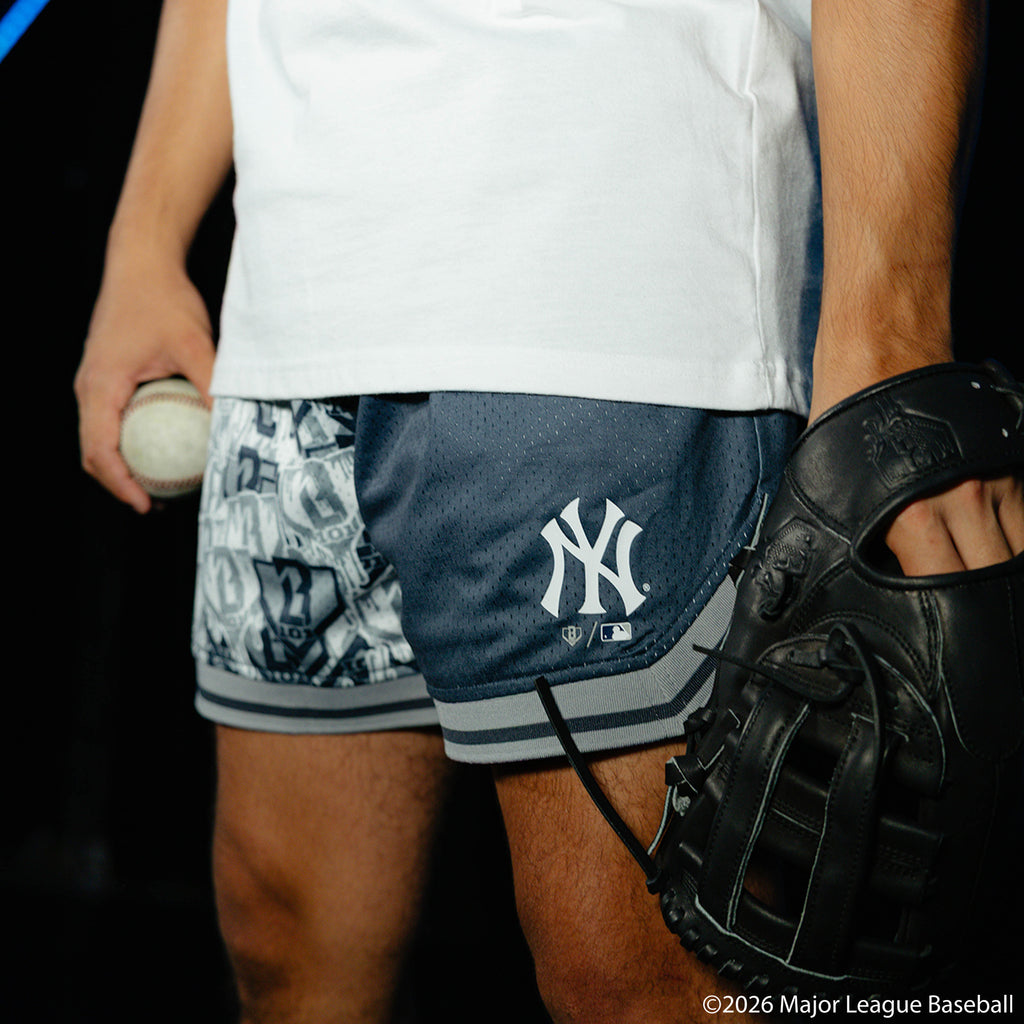 Adult model wearing navy shorts with "New York Yankees Sticker Court" design