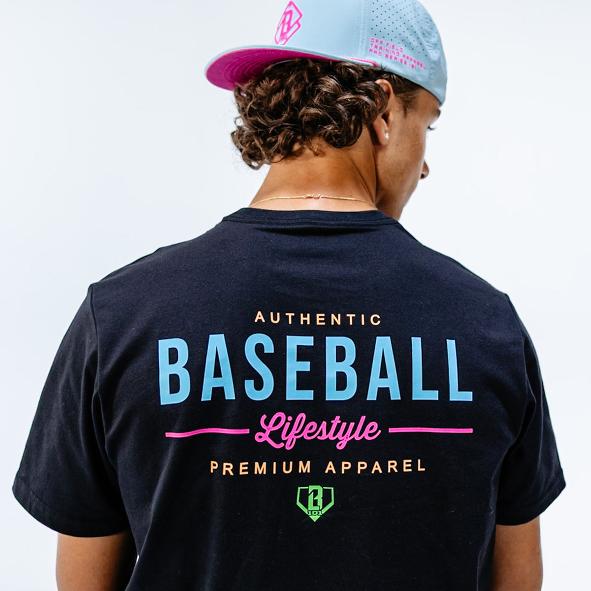 Person wearing a black t-shirt with 'Authentic Baseball Lifestyle Premium Apparel' text on the back.