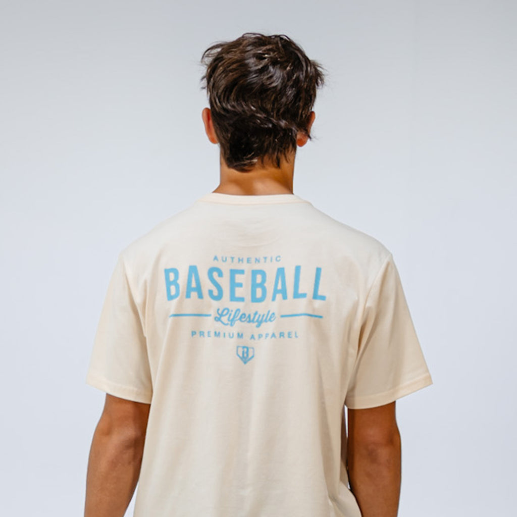 Person wearing a beige t-shirt with 'Baseball Lifestyle' text on the back against a white background