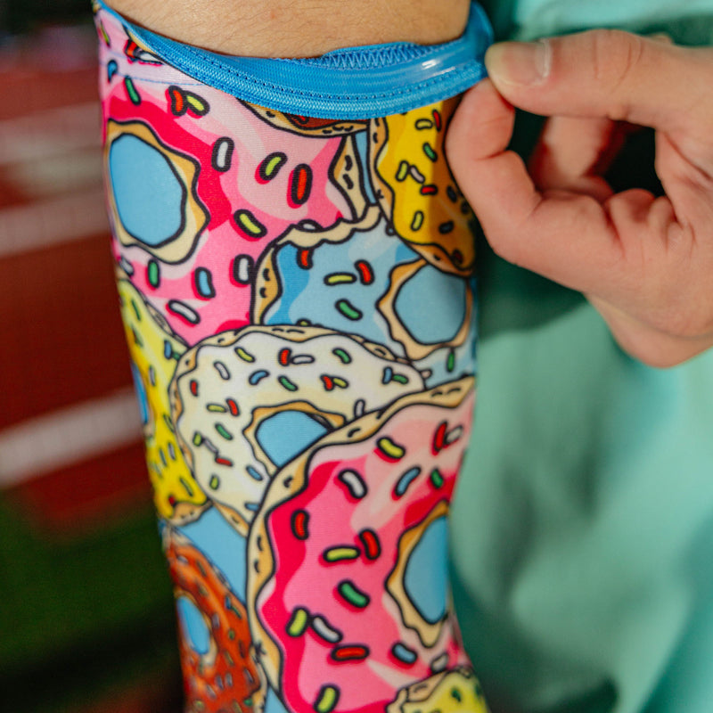 Close-up of donut arm sleeve being pulled up showing blue elastic band at the bicep