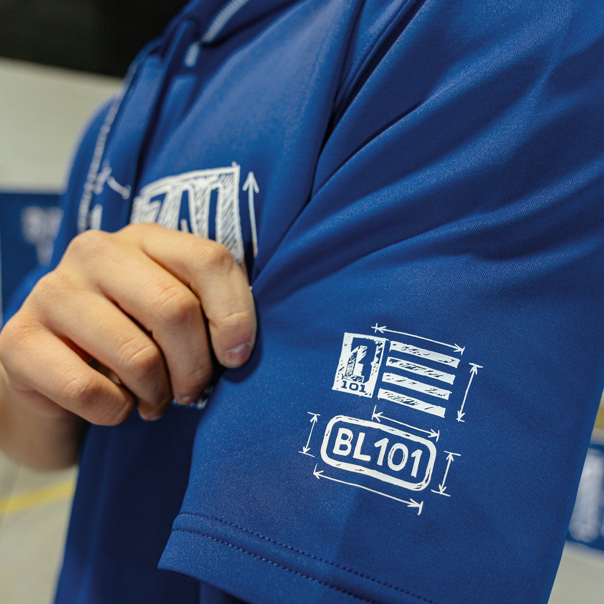 Person wearing a blue shirt with 'BL101' logo and text.