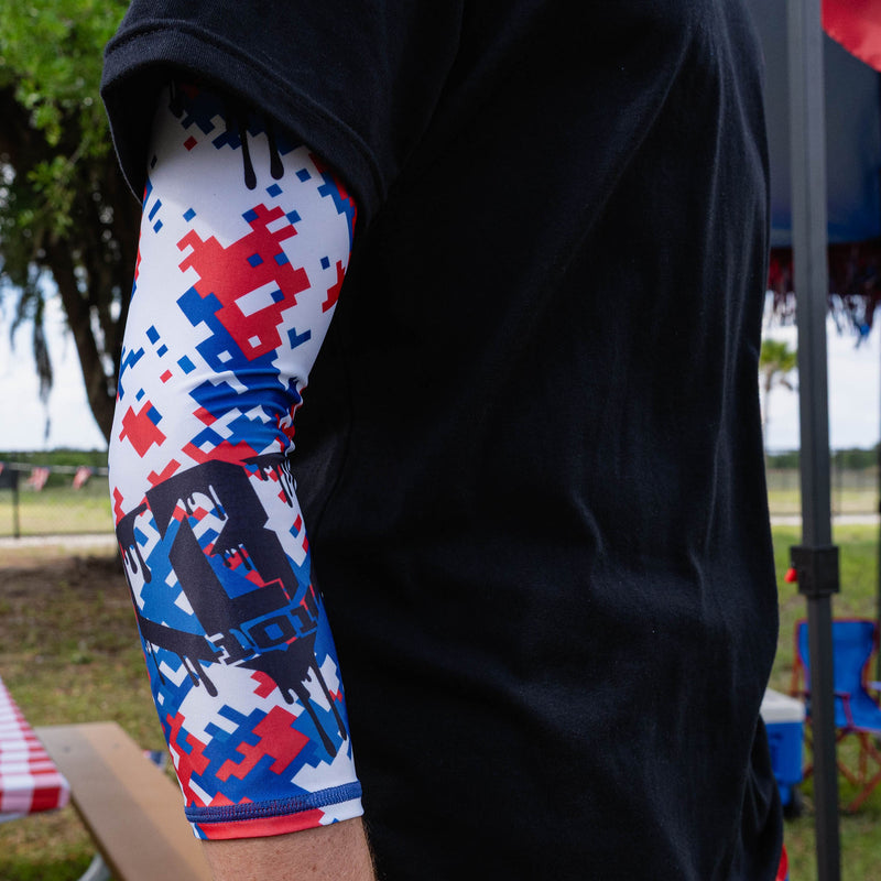 Side close-up of adult arm wearing red white and blue digital camo sleeve showing full drip BL101 logo detail
