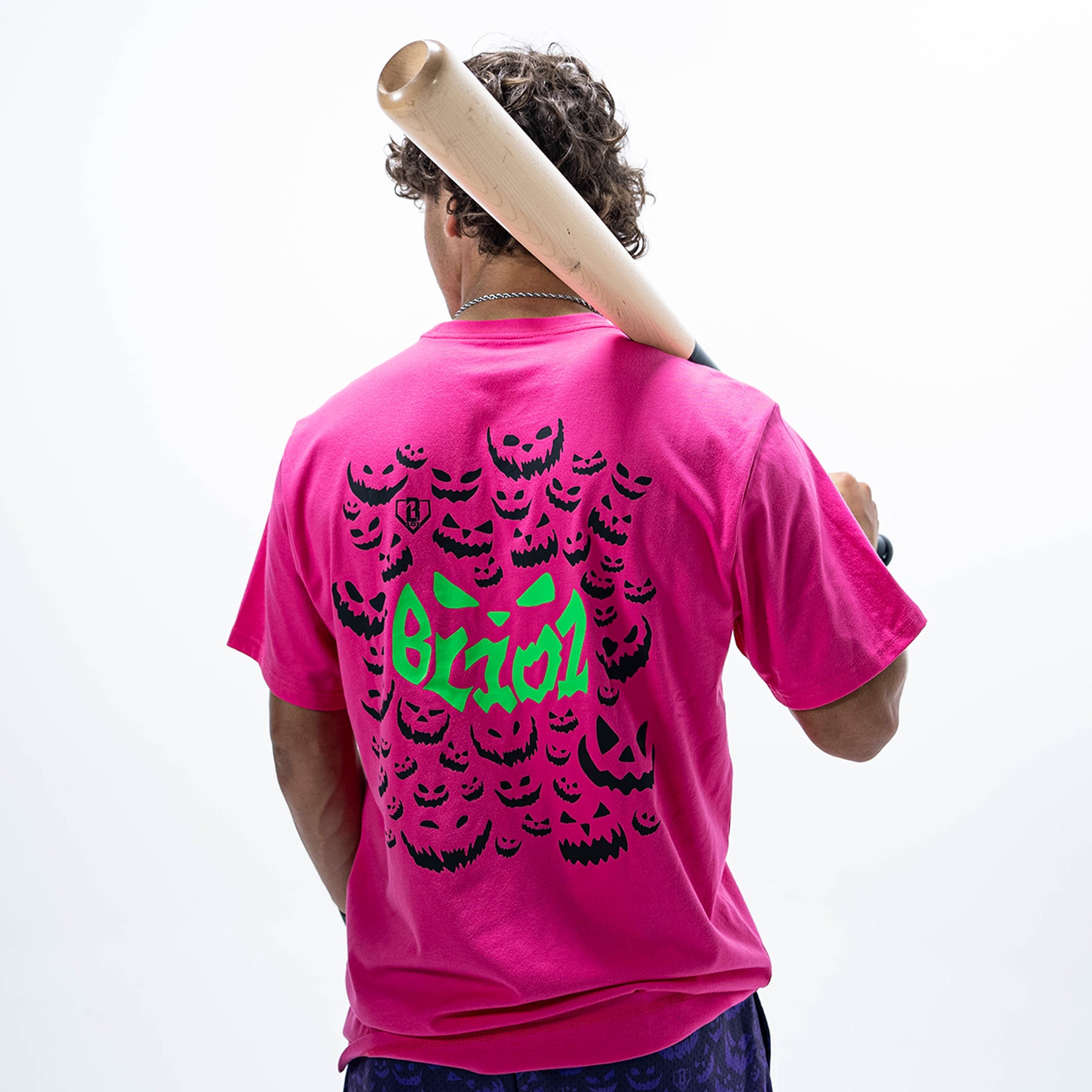 Adult model wearing pink graphic tee with "Jack O' Lantern Team" design