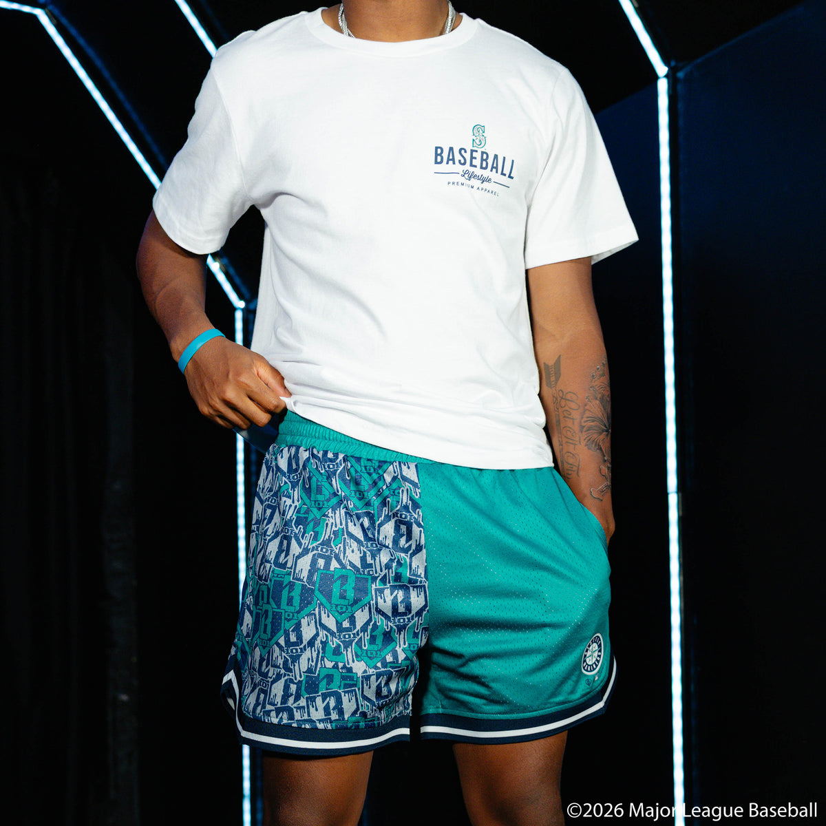 Adult model wearing green shorts with "Seattle Mariners Sticker Court" design