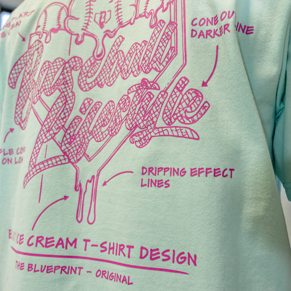 Light green t-shirt with pink ice cream cone design and Baseball Lifestyle text on a white background