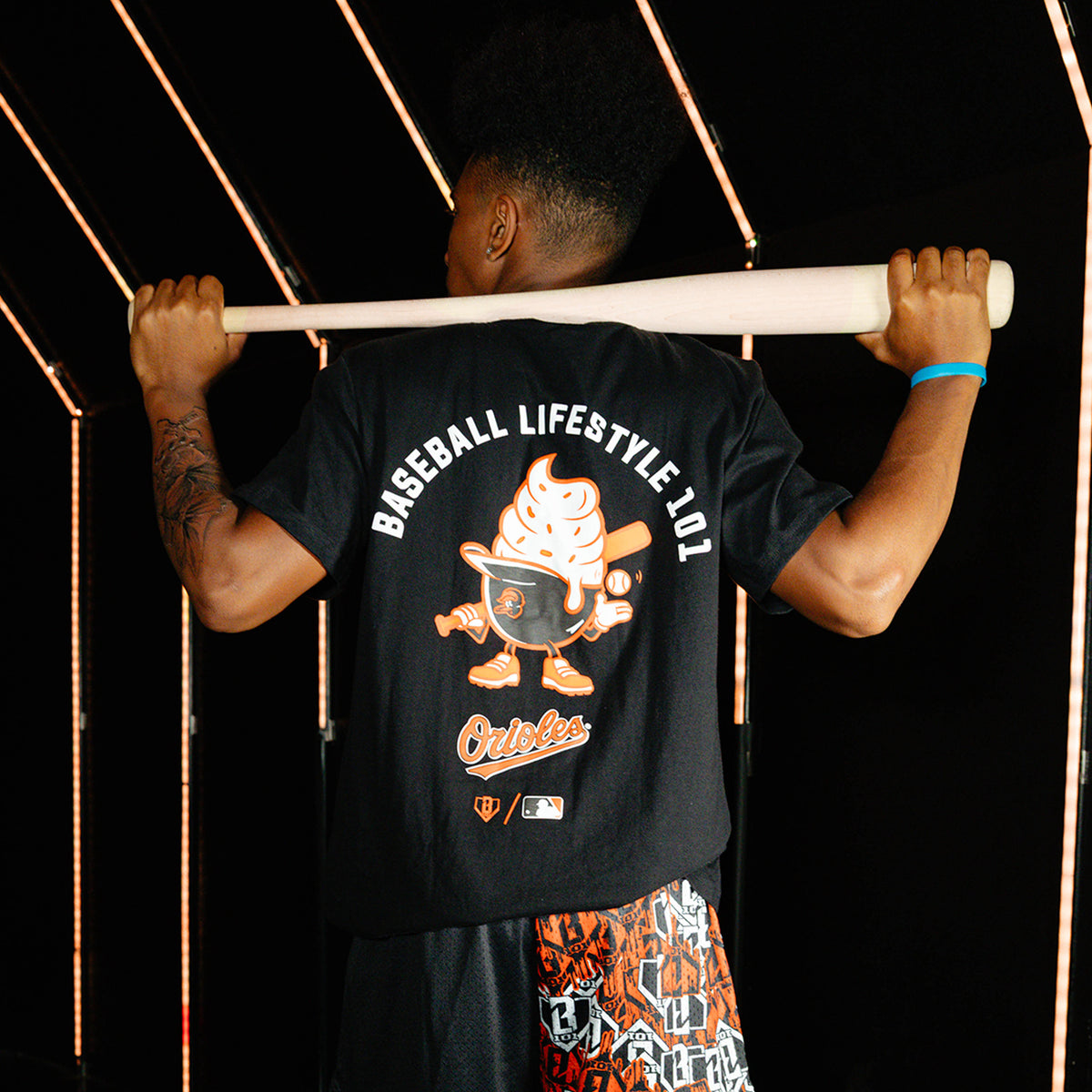 Adult model wearing black graphic tee with "Baltimore Orioles Ice Cream Cap" design