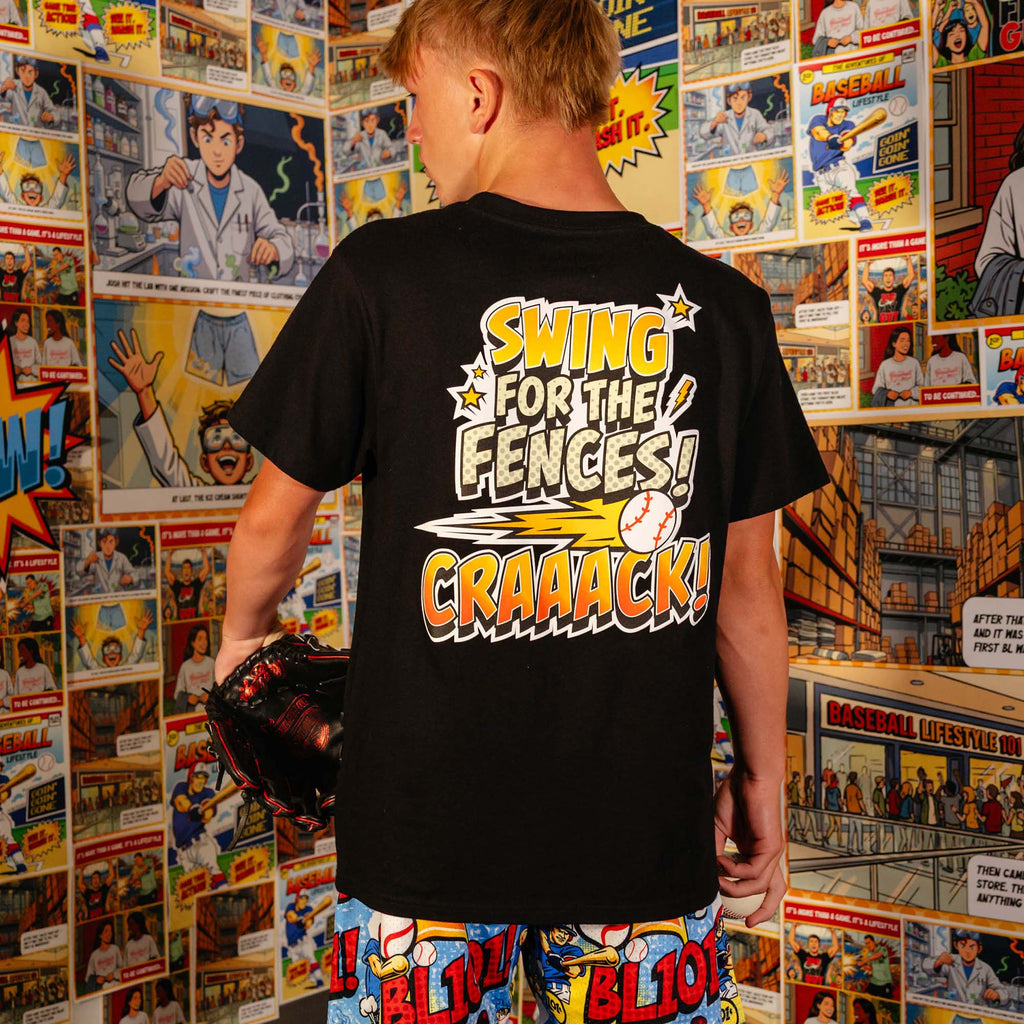 Adult model wearing black graphic tee with "Swing For The Fences" design