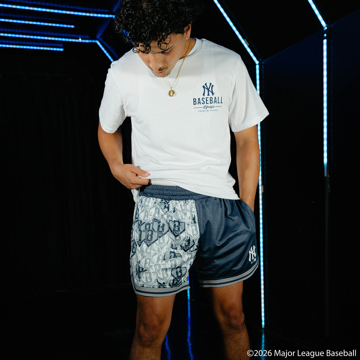 Adult model wearing navy shorts with "New York Yankees Sticker Court" design