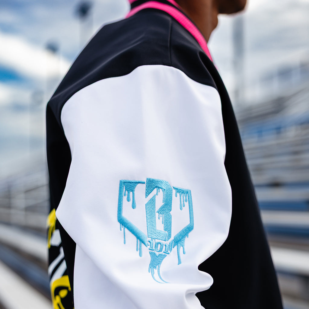 Person wearing a black and white jacket with a blue BL101 logo in an outdoor setting