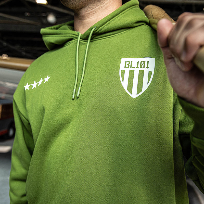 close up of man wearing Army green Hoodie with white BL101 armor design and five white stars in front of hoodie 