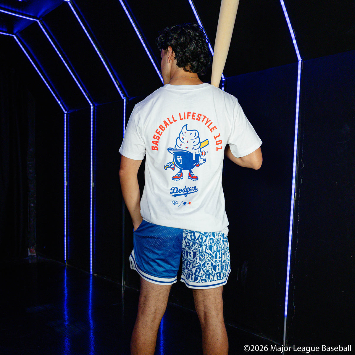 Adult model wearing blue shorts with "Los Angeles Dodgers Sticker Court" design