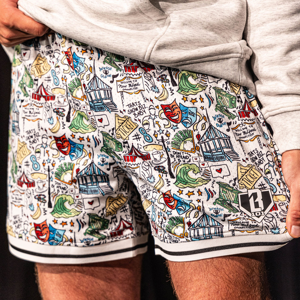 Close-up of the white Jackson Olson x BL101 Hometown Shorts highlighting the full all-over illustrated print, striped hem, and BL101 home plate logo