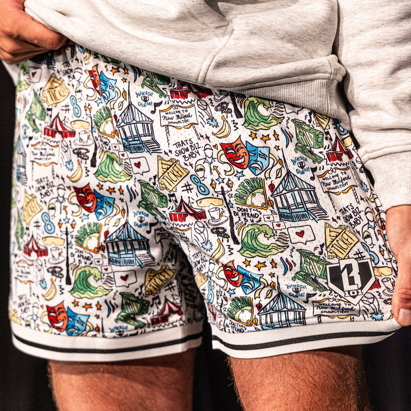 Close-up of the white Jackson Olson x BL101 Hometown Shorts highlighting the full all-over illustrated print, striped hem, and BL101 home plate logo