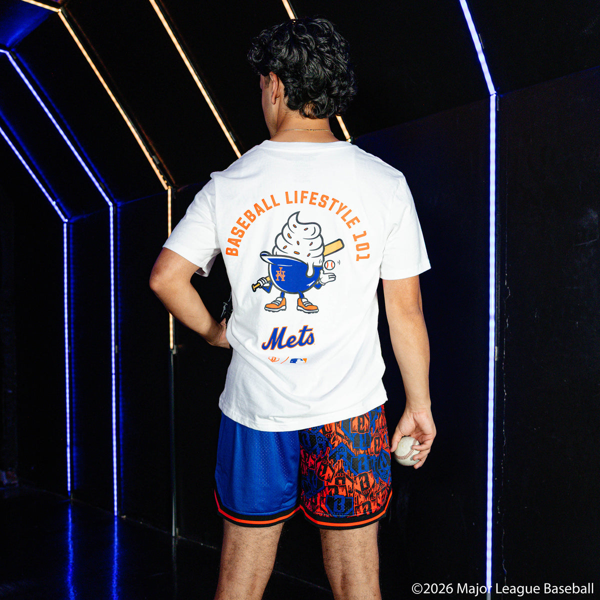 Adult model wearing blue shorts with "New York Mets Sticker Court" design