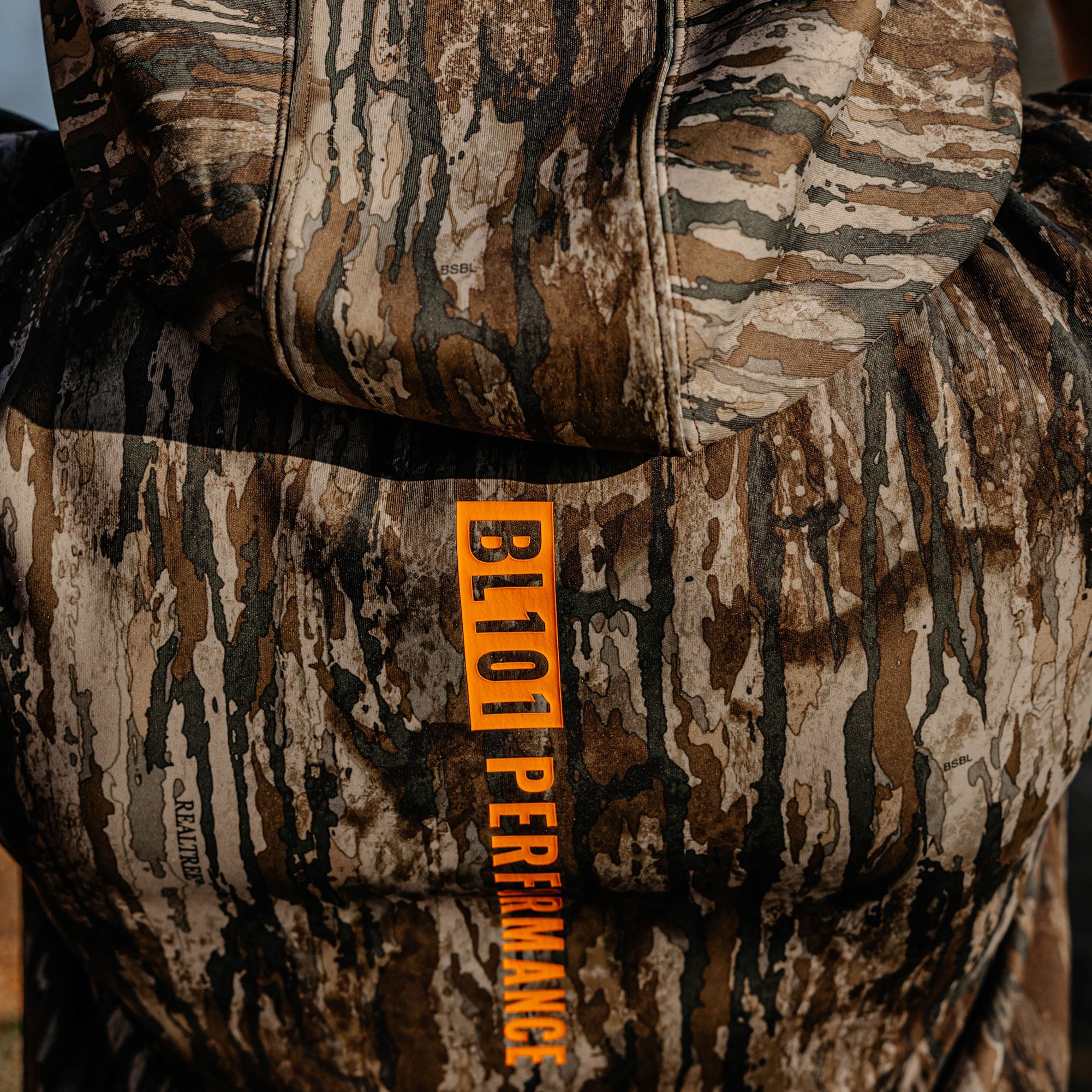 Camouflage hoodie with 'BL101 Performance' label on a blurred background