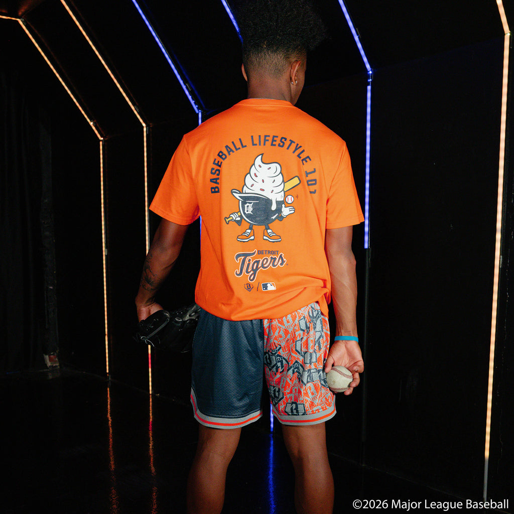 Adult model wearing navy shorts with "Detroit Tigers Sticker Court" design