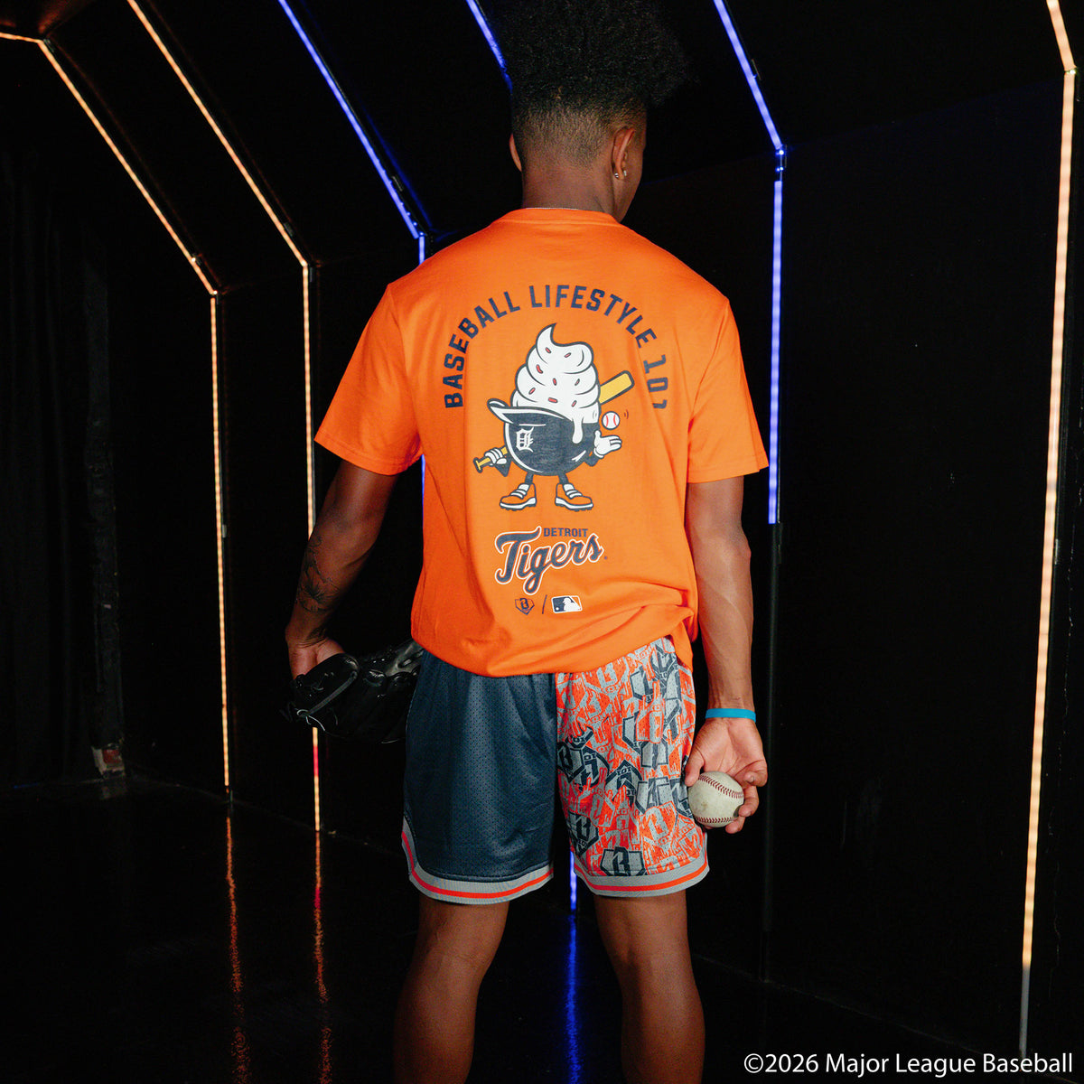 Adult model wearing navy shorts with "Detroit Tigers Sticker Court" design