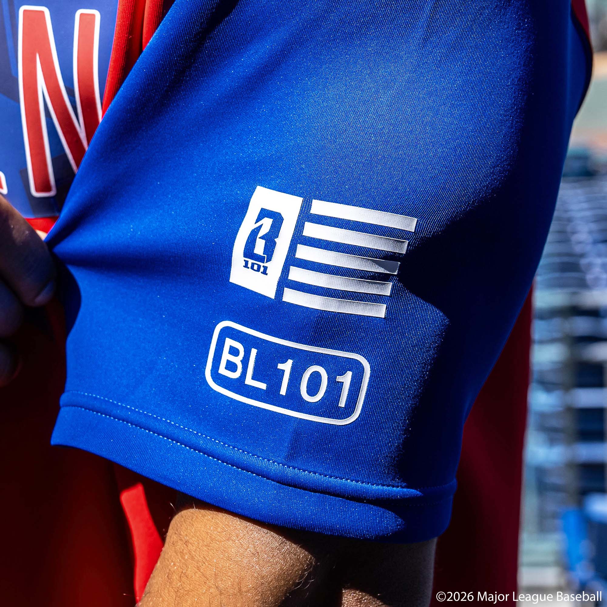 Adult model wearing Red, White & Blue short sleeve hoodie with "BL101 All-Star BSBL-SZN V3" design