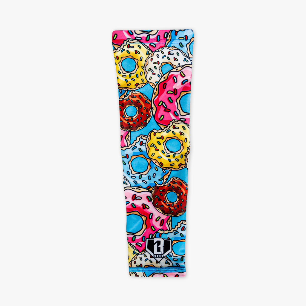 Donut arm sleeve laid flat on white background with colorful frosted donut and sprinkle print and BL101 logo patch at wrist